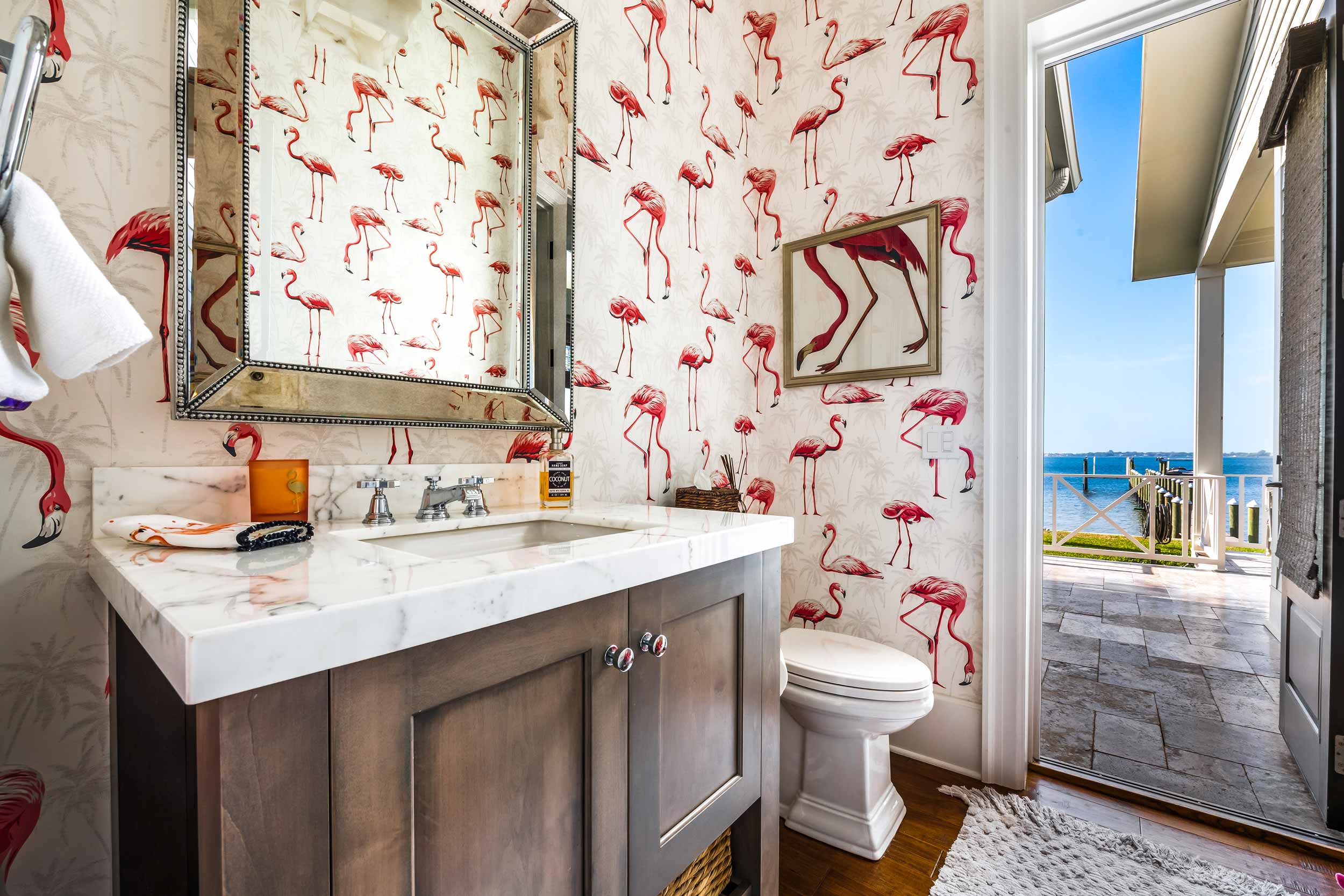 Custom designed bathroom with flamingo wallpaper that opens out to an outdoor space